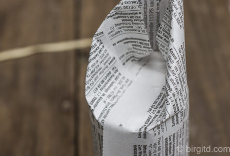 Das überstehende Papier rundherum, wie beim Einpacken von Geschenken, zur Mitte hin falten - dabei mit der offenen, losen Seite beginnen Das überstehende Papier rundherum, wie beim Einpacken von Geschenken, zur Mitte hin falten - dabei mit der offenen, losen Seite beginnen