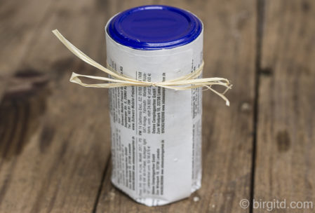 Das umwickelte Glas auf den gefalteten Papierboden stellen und mit einem Bändchen den entstandenen Papiertopf zusammenbinden. Das umwickelte Glas auf den gefalteten Papierboden stellen und mit einem Bändchen den entstandenen Papiertopf zusammenbinden.